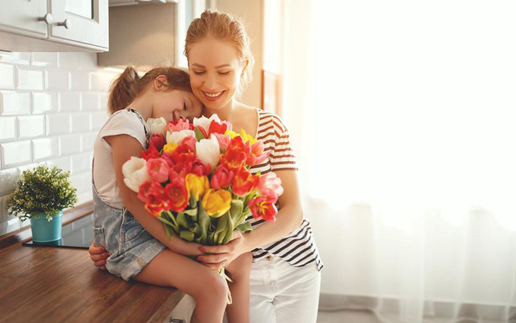 Madre e hija con ramo de flores
