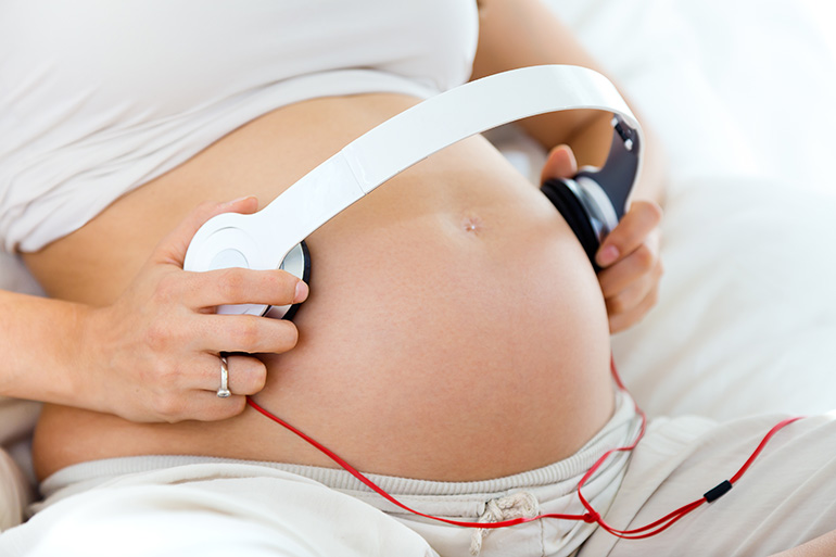 Mujer embarazada escuchando musica con su bebe