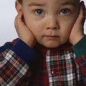 Niño con los oídos tapados